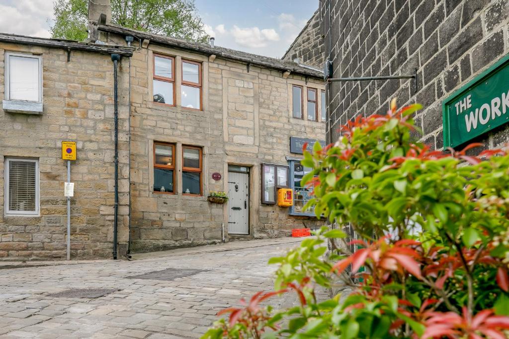 an old stone building with a street in front of it at Weavers Cottage in Hebden Bridge