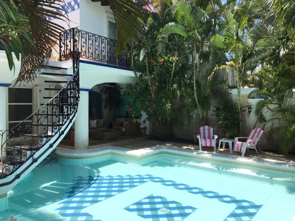 a house with a swimming pool with a balcony at La Villa du Golf à Cancun Hotel Boutique in Cancún