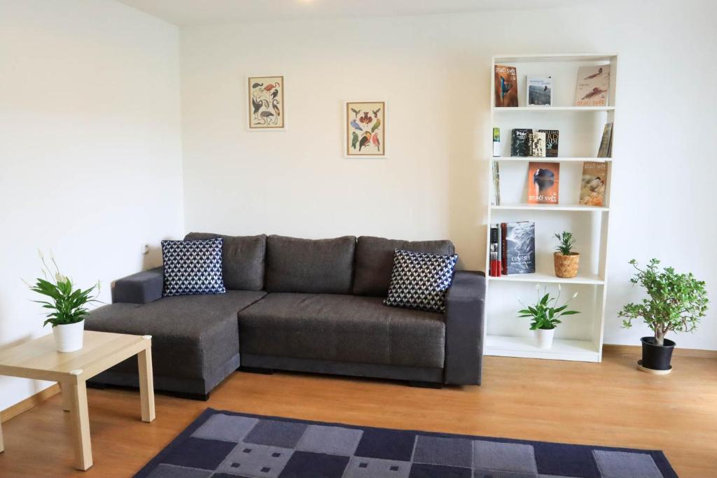 uma sala de estar com um sofá e uma mesa em Pohodlný apartmán s ptačí zahradou em Uherské Hradiště