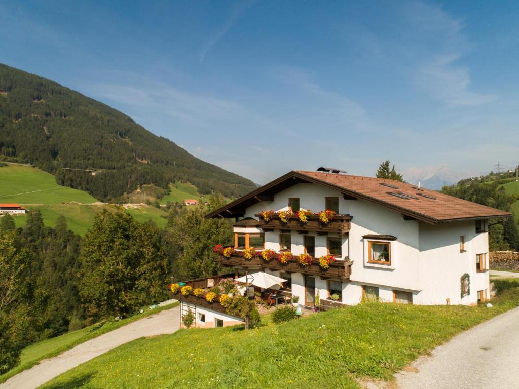 una casa su una collina con dei fiori sopra di Haus Kienast a Pfons