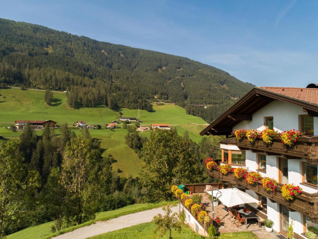 Un edificio su una collina con dei fiori sopra di Haus Kienast a Pfons