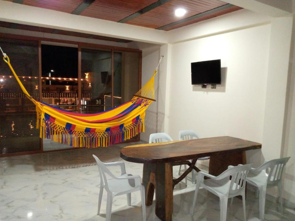 a table and chairs with a hammock in a room at hermoso apartamento en guaduas (apto 202) in Guaduas