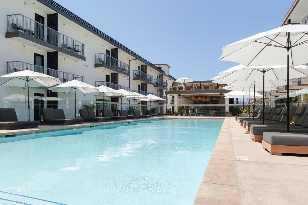 a large swimming pool with chairs and umbrellas at Sonder Lüm in Inglewood