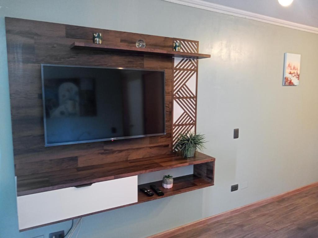 sala de estar con TV en la pared en Departamento Amoblado Vacaciones Cavancha, en Iquique