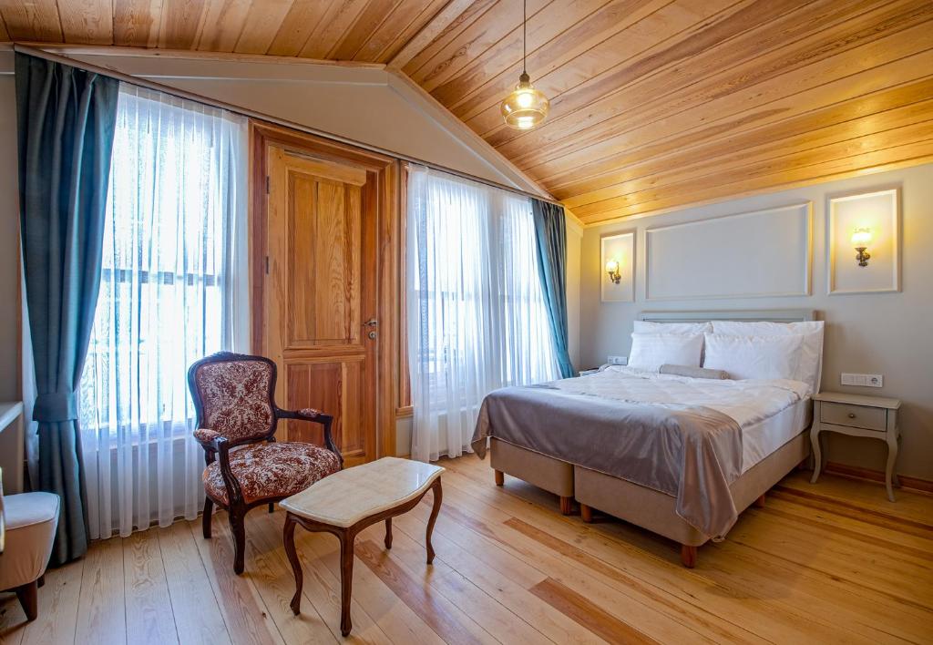 1 dormitorio con 1 cama y 1 silla en una habitación en İkiz Konak Boutique Hotel, en Estambul