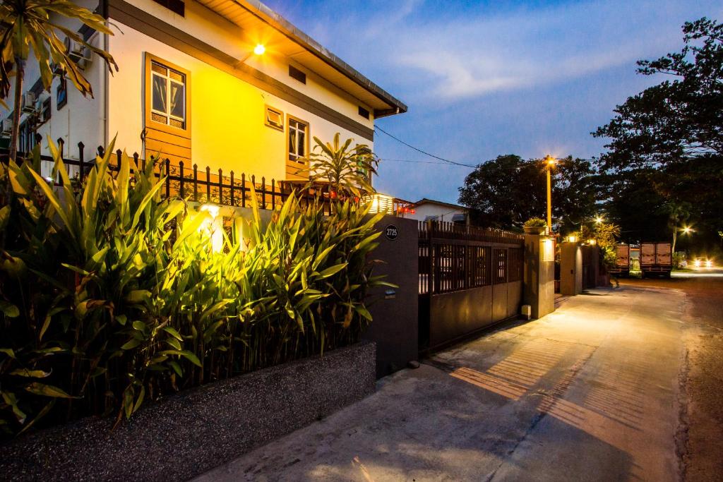 a house with a fence next to a street at Value Inn Homestay in Butterworth