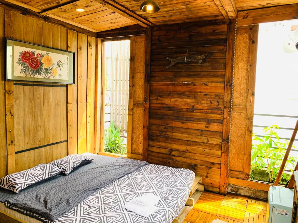 1 dormitorio con 1 cama en una pared de madera en Mobylette Sai Gon, en Ho Chi Minh