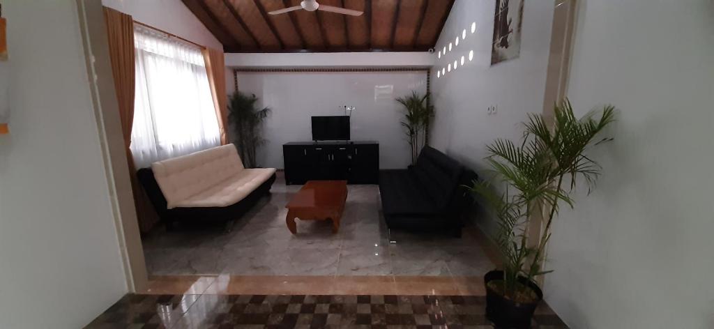 a living room with a couch and a chair at The Balisunny House in Denpasar