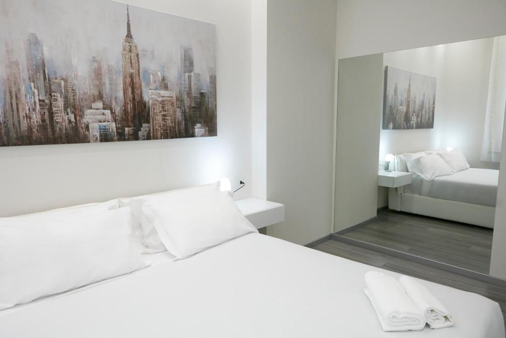 LA CORTE LUXURY APARTMENT في ميلانو: غرفة نوم بيضاء مع سرير أبيض وحمام
