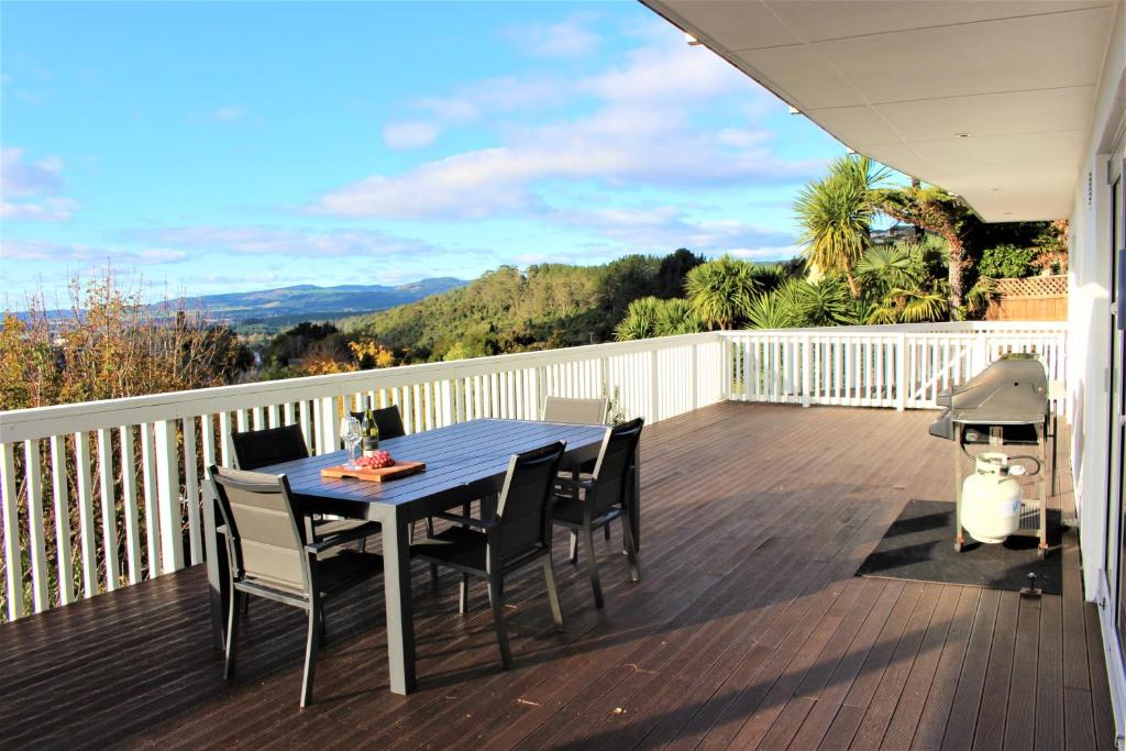 una mesa y sillas en una terraza con parrilla en Serenity Views en Rotorua