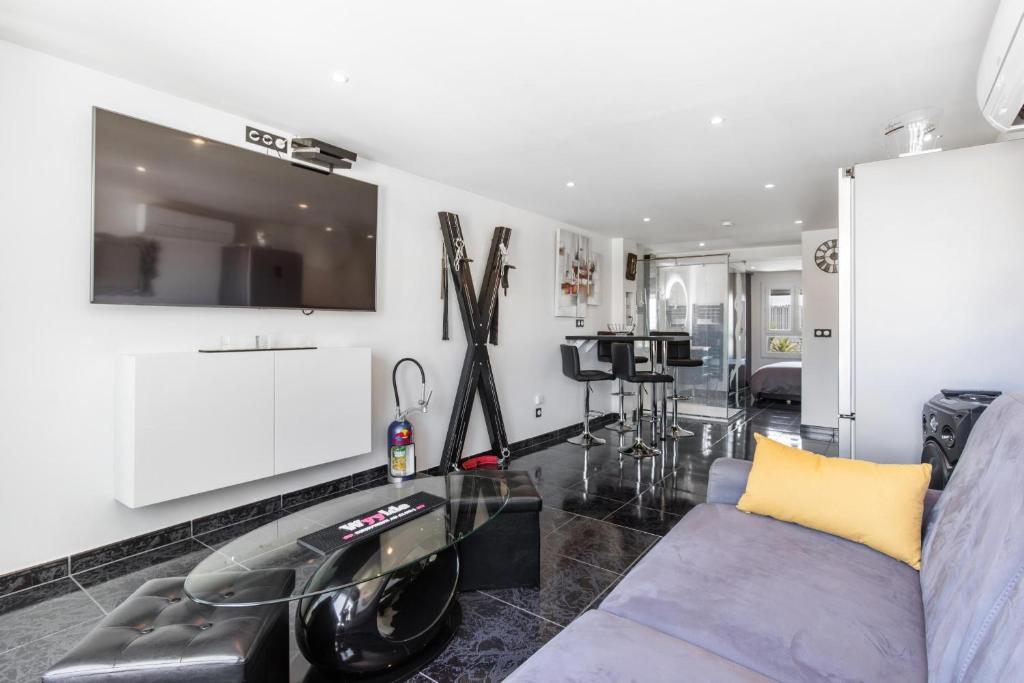 un salon avec un canapé et une table en verre dans l'établissement Village Naturiste R4N - Cap Caline Port Nature Coursive Luxe, au Cap d'Agde