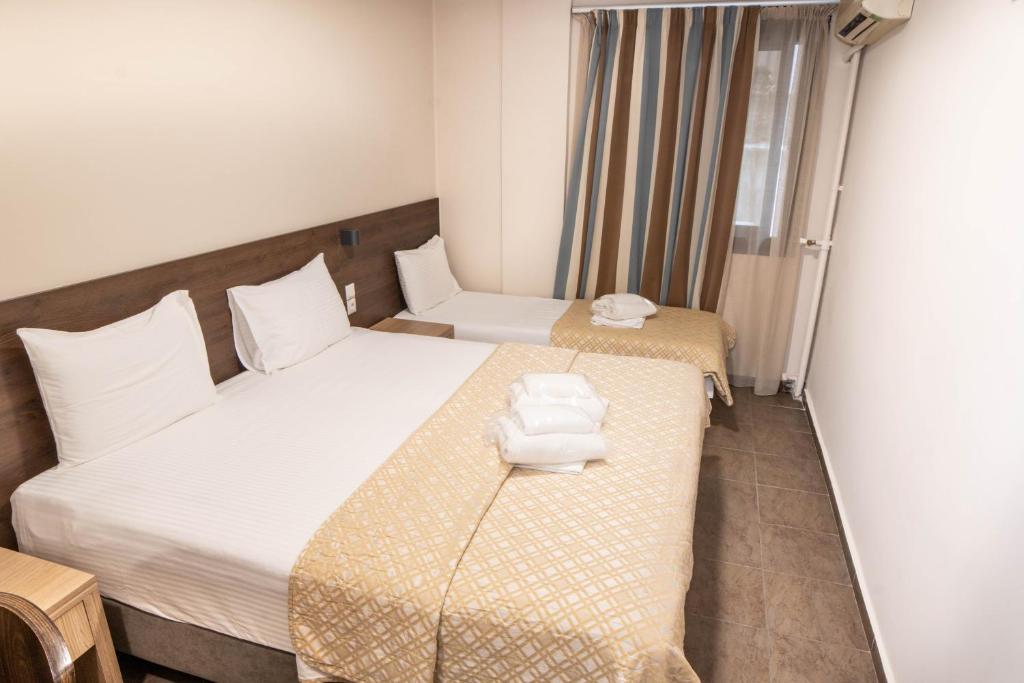 a hotel room with a bed and two twin beds at Anita Hotel in Piraeus