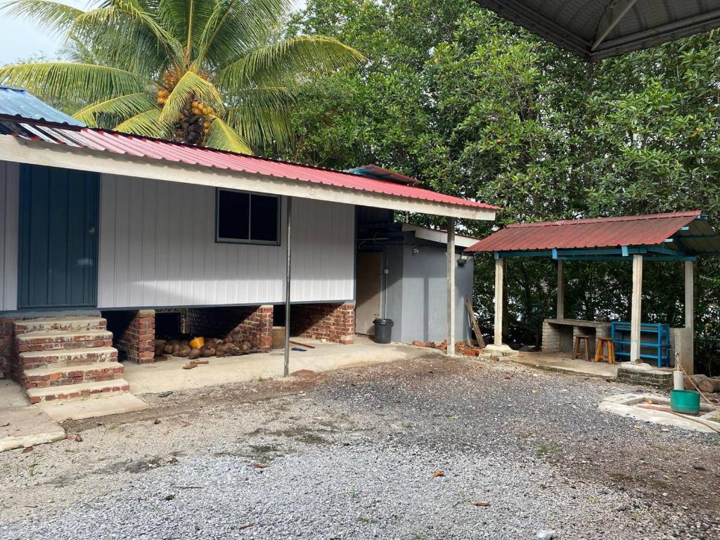 CabinStay Cikgu Sungai Batu Besi في سونغاي بيتاني: منزل به موقد من الطوب وسقف