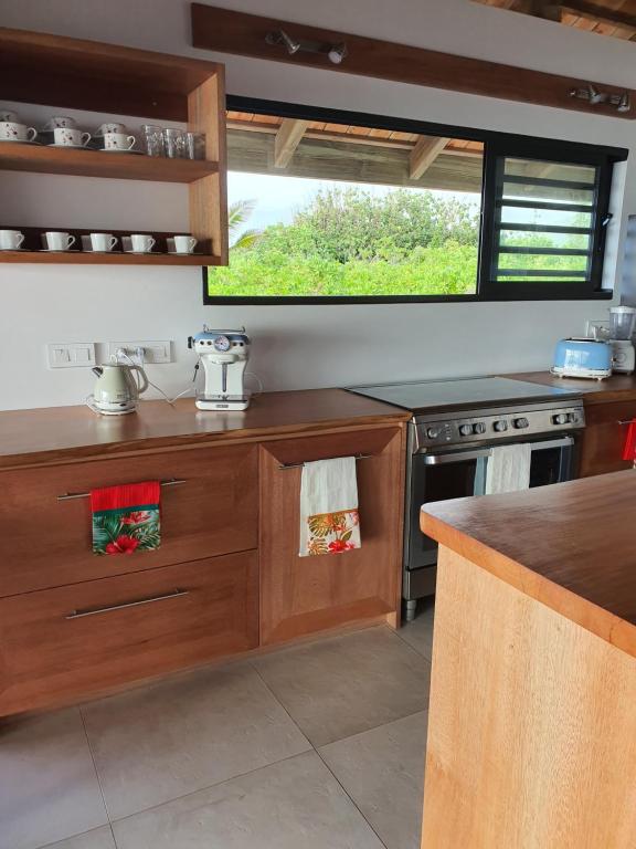 a kitchen with wooden cabinets and a stove top oven at Moorea Lodge in Temae