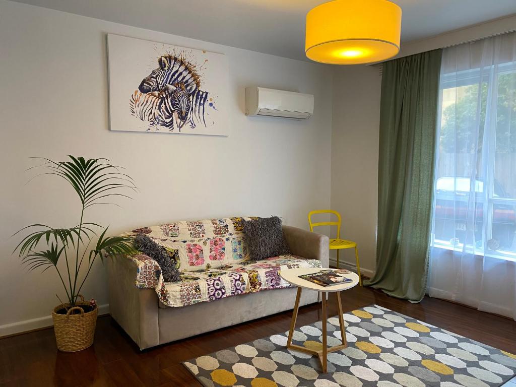 ein Wohnzimmer mit einem Sofa und einem Tisch in der Unterkunft Poets Retreat in Melbourne