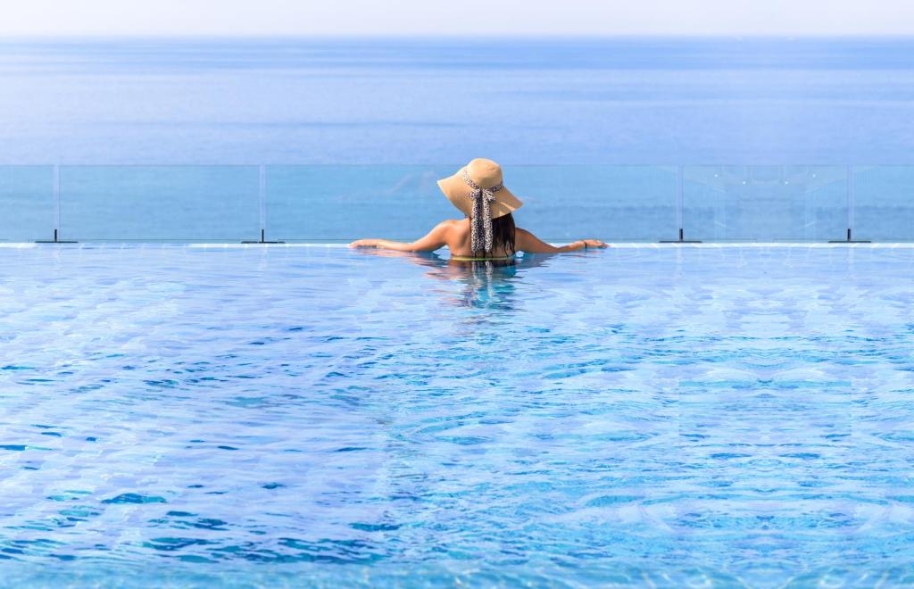 una persona en un sombrero sentada en el agua en Grabel Hotel Jeju, en Jeju