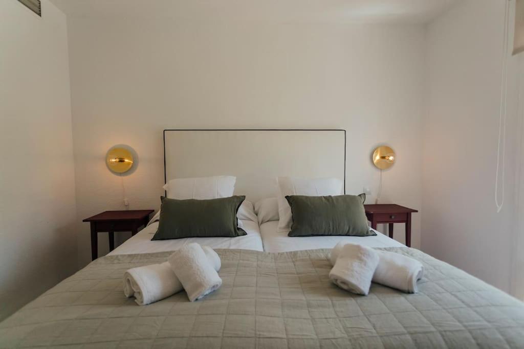 1 cama blanca grande con 2 almohadas en O&L Murillo Bright apartment - terrace & parking en Sevilla