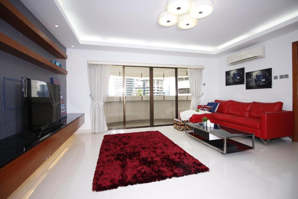 a living room with a red couch and a red rug at UBN by Plush in Kuala Lumpur