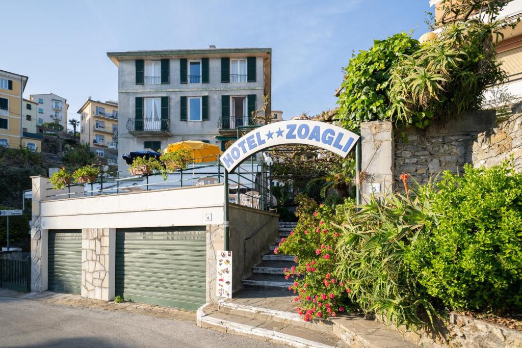 a building with a garage and a sign that reads quality karma at Hotel Zoagli in Zoagli