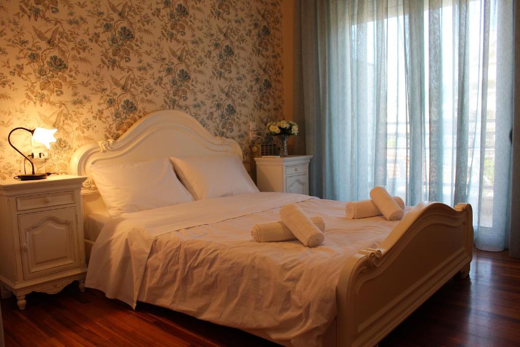 1 cama blanca con 2 almohadas en el dormitorio en Vintage Home, en Volos