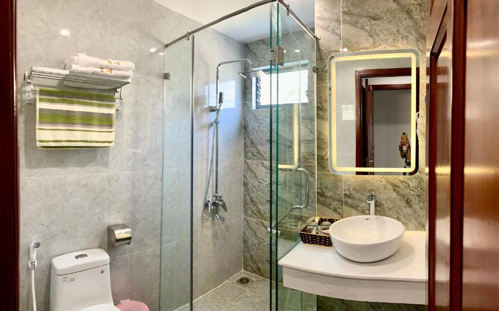 Sunset Hotel & Apartment في فنغ تاو: حمام مع دش ومغسلة ومرحاض