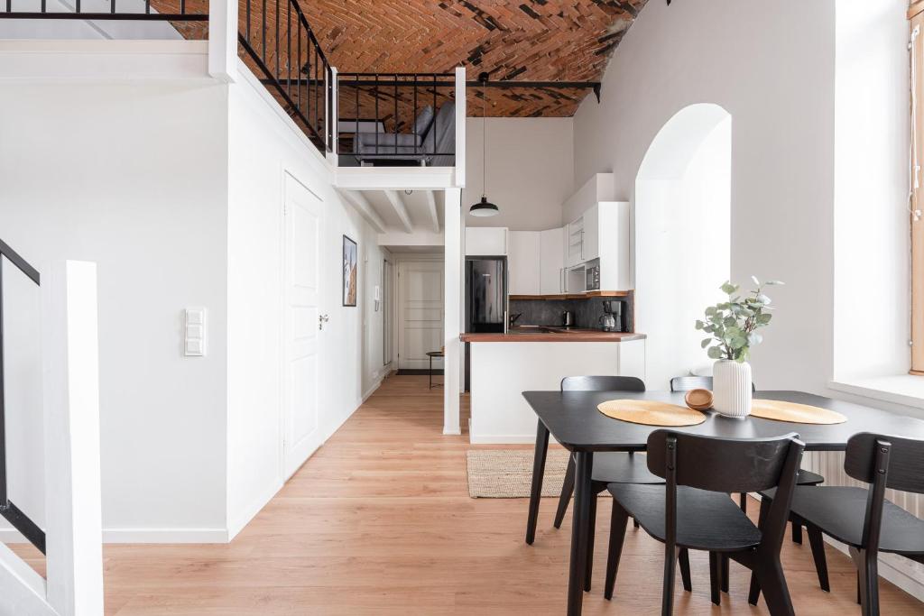 a kitchen and dining room with a table and chairs at 2ndhomes Tampere "Klingendahl" Apartment - Historical Apt with Sauna & Free Parking in Tampere