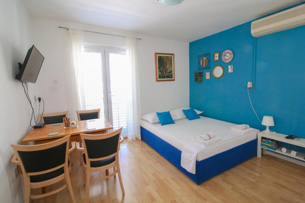 a bedroom with a bed and a desk with a computer at Apartment Bili-sea view apartment in the center in Makarska