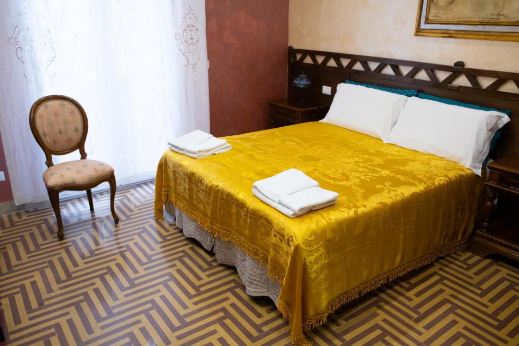 um quarto com uma cama amarela e uma cadeira em Bed and Breakfast Dolce Noemi em Reggio di Calabria