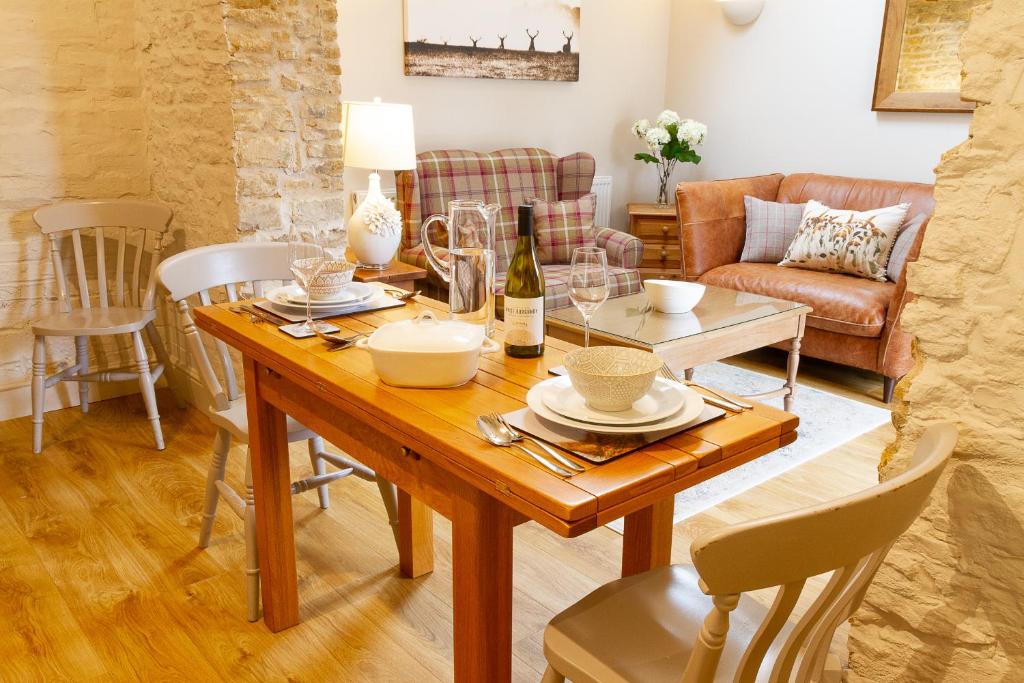 a living room with a wooden table and chairs at The Little Bothy in Wansford
