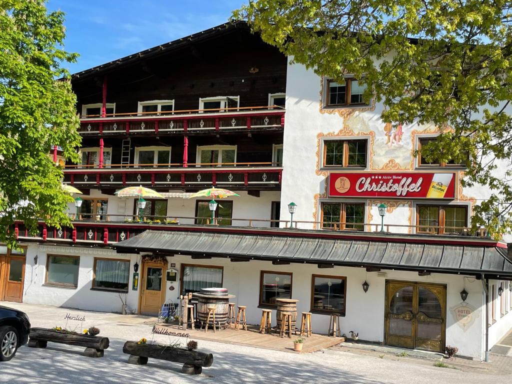 un edificio con mesas y sillas delante de él en Hotel Christoffel en Niederau