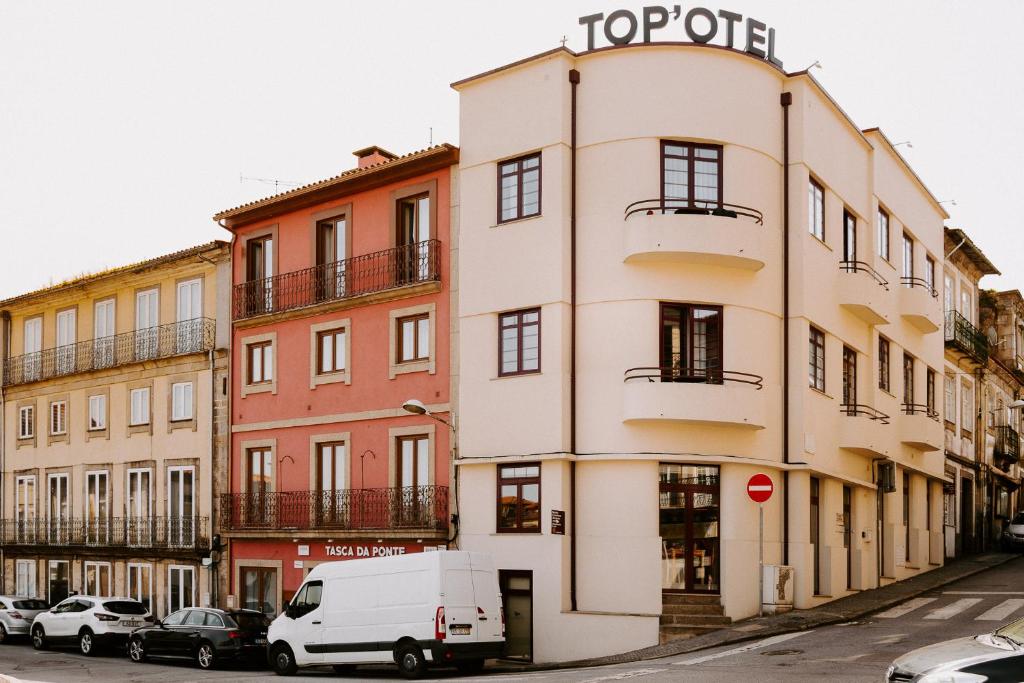 una furgoneta blanca estacionada frente a un edificio en Top'Otel, en Barcelos