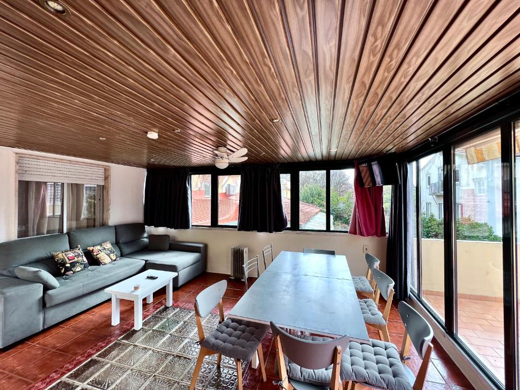 uma sala de estar com uma mesa e um sofá em Flores Terrace Apartment em Lisboa