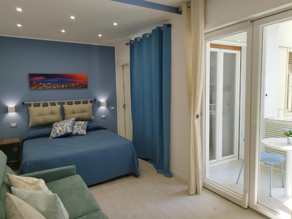 niebieska sypialnia z łóżkiem i kanapą w obiekcie B&B Molo Partenope w mieście Neapol
