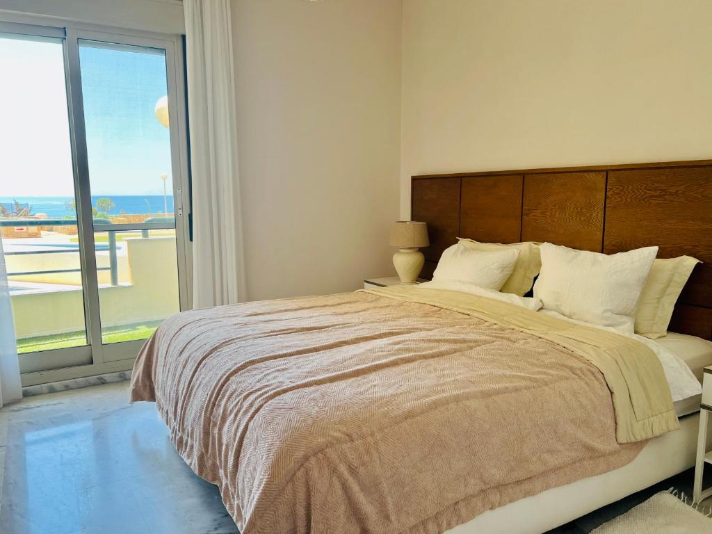Un dormitorio con una cama grande con una ventana grande. en Apartment Sea Breeze – Apartamento Brisas del Mar, en Benalmádena