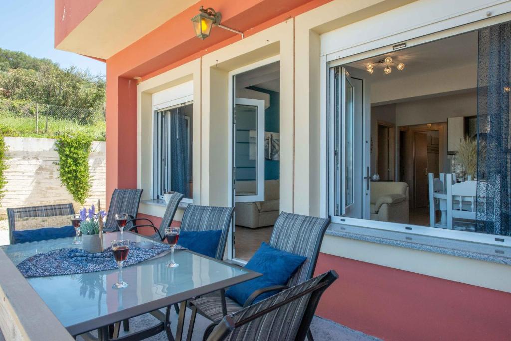 patio con mesa y sillas en el balcón en Darmanin Αpartment 4 Gyalos Corfu, en Astrakeri