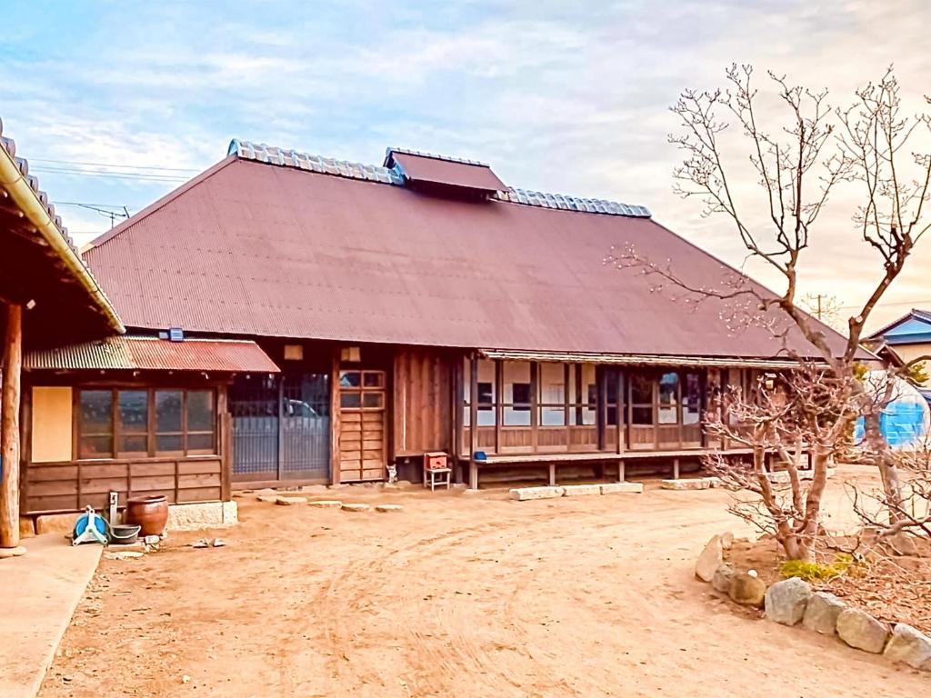 um grande edifício de madeira com um grande telhado em GAMP HOUSE 江戸農家古民家ゲストハウス Old Folk Farm GuestHouse em Iwaki