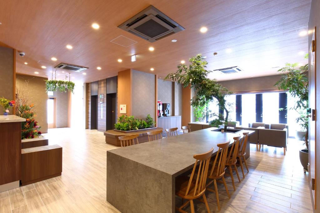 an office lobby with a large table and chairs at LUXCARE HOTEL in Osaka