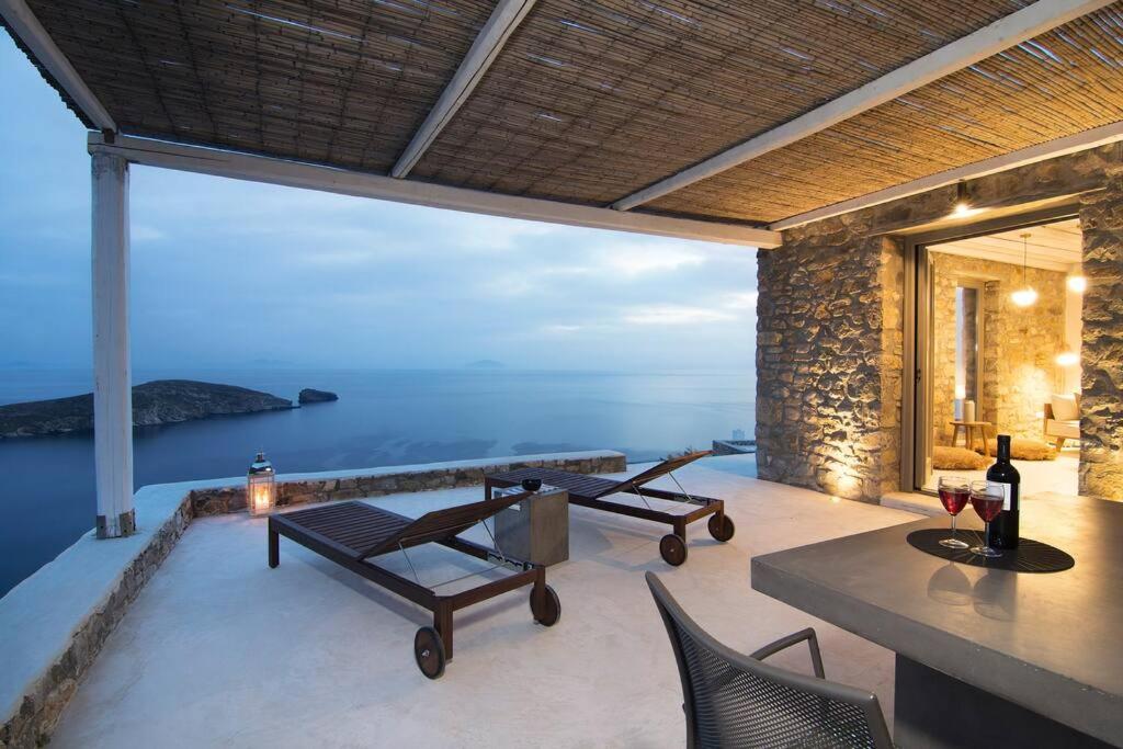 a patio with a table and chairs and the ocean at Dreamy Cycladic Luxury Summer House 2 in Serifos Chora