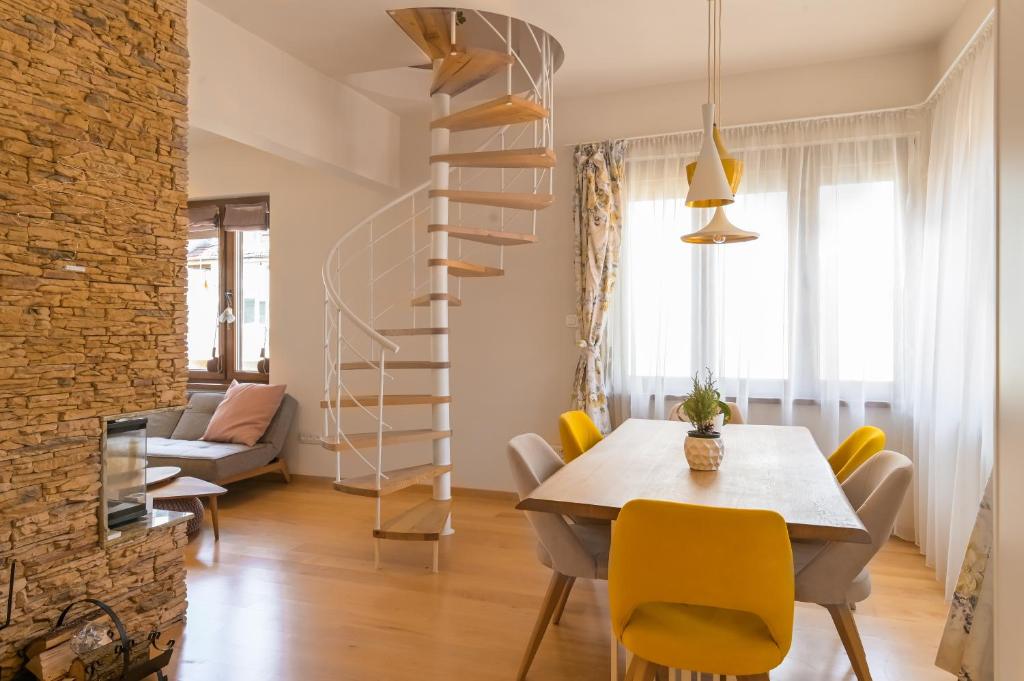 une salle à manger avec une table et un escalier en colimaçon dans l'établissement Designer Maisonette with Top Central Location, à Sofia