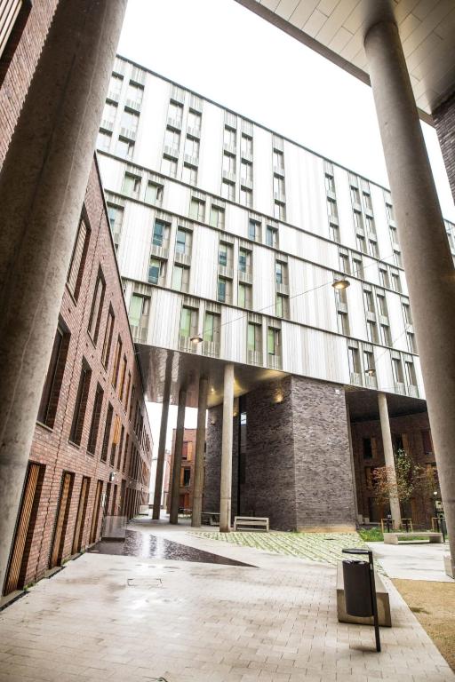 a large building with a bench in front of it at Paradise Village Coventry in Coventry