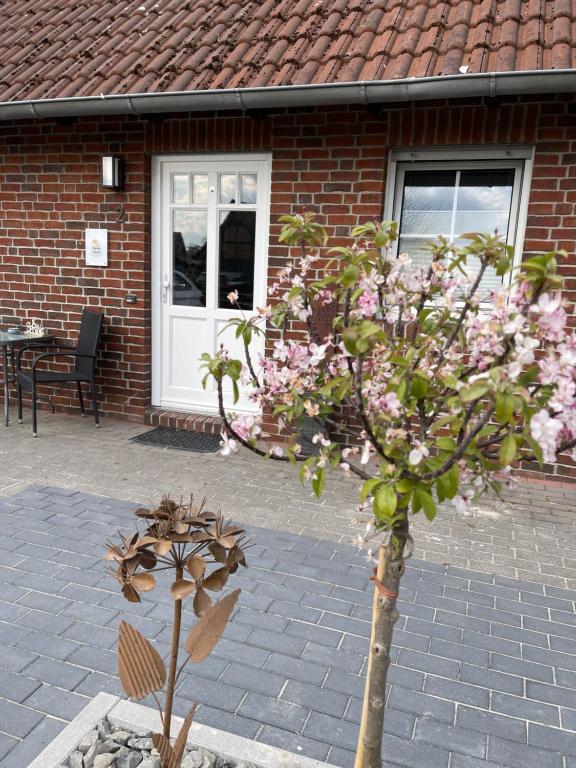 einen Baum mit rosa Blumen vor einem Gebäude in der Unterkunft Ferienwohnung Kleine Auszeit in Hagenburg