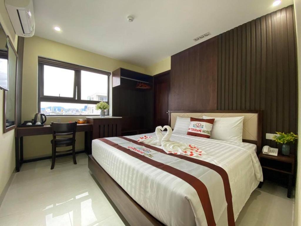 a bedroom with a bed with two swans on it at New Tourane Hotel in Danang
