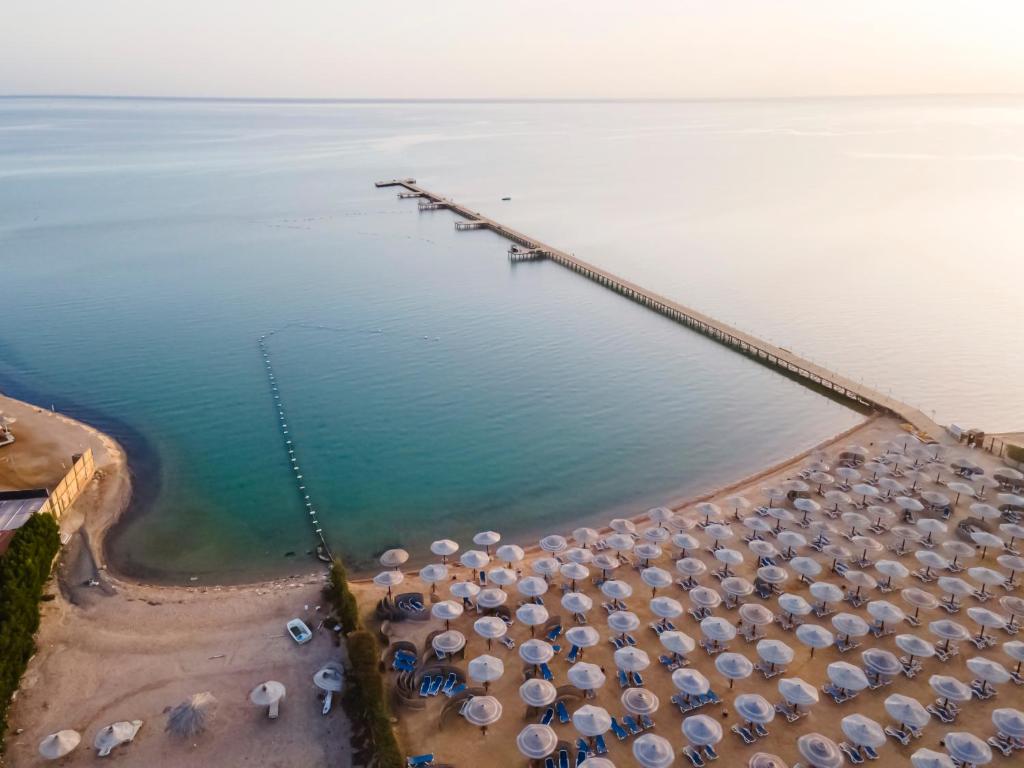 a beach filled with lots of beach chairs and umbrellas at AMC Royal Hotel & Spa in Hurghada