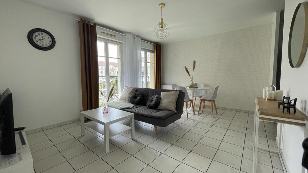a living room with a couch and a table at Apartment 1 bedroomed with Balcony 10min from Disneyland Paris in Bussy-Saint-Georges