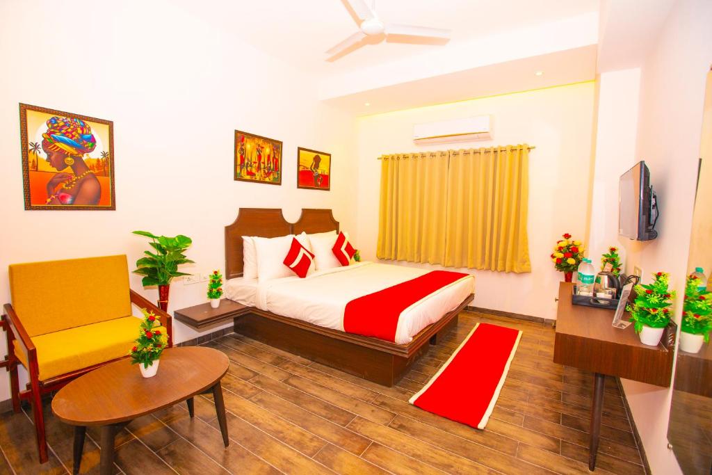 ein Schlafzimmer mit einem Bett, einem Tisch und einem Stuhl in der Unterkunft Octave Parkland Suites in Nagpur