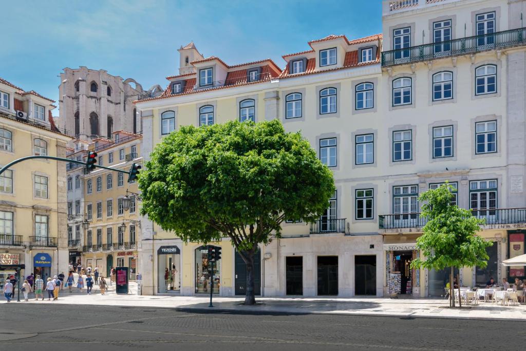 リスボンにあるNicola Rossio Hotelの白い大きな建物の前の木