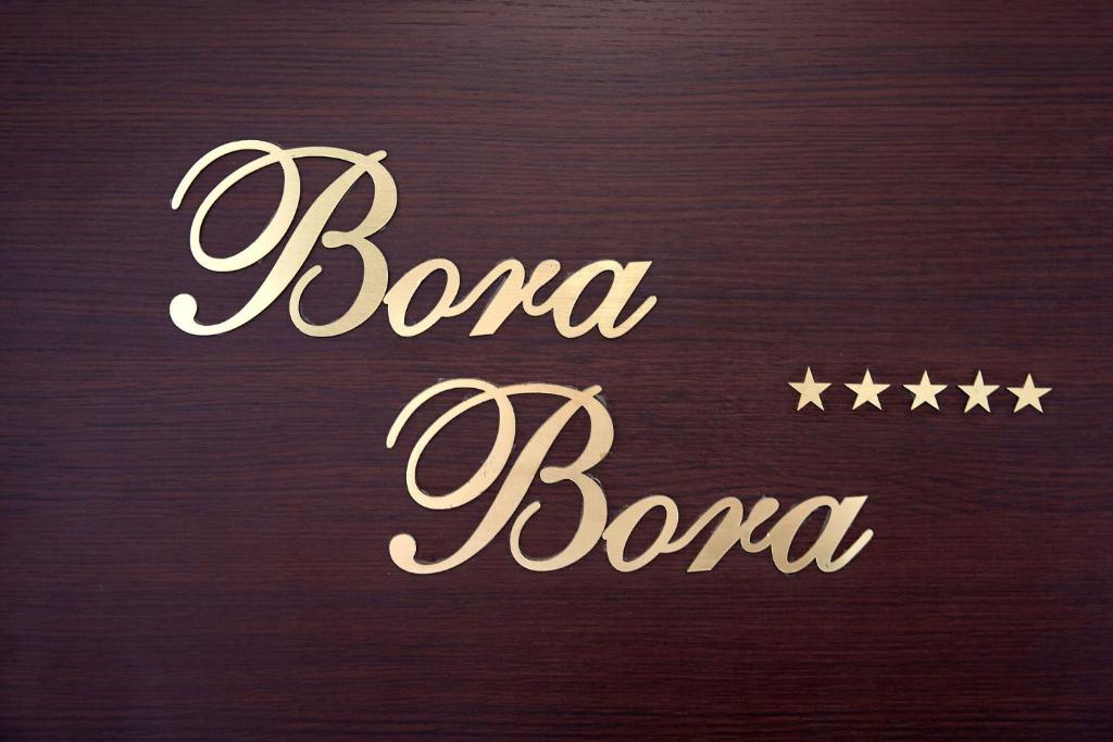 uma mesa de madeira com um sinal que lê bond boca em Apartament Bora Bora Boutik Cytadell em Eforie Nord