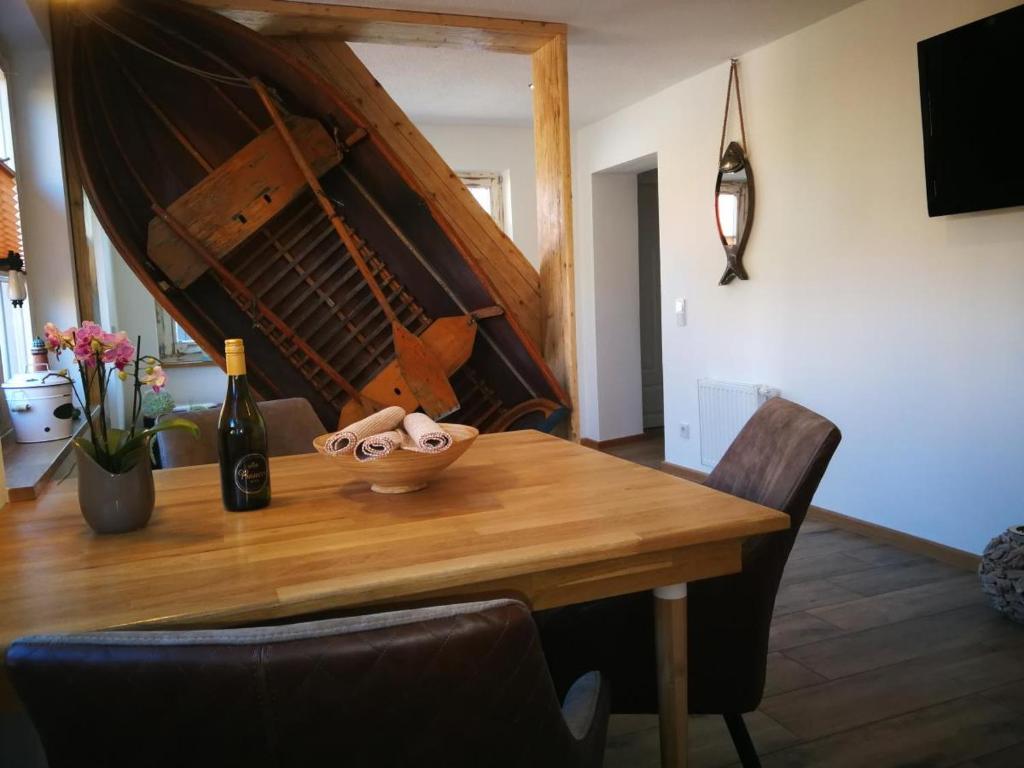 a wooden table with a bottle of wine and a bowl on it at Boddenkahn in Born