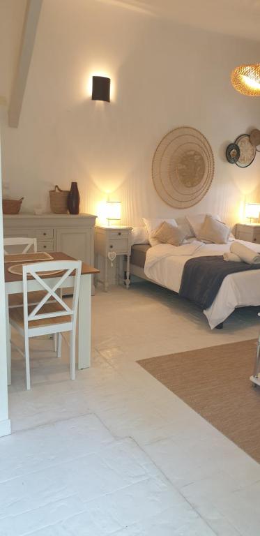 a bedroom with two beds and a table and a desk at Chambre Lily in Parranquet