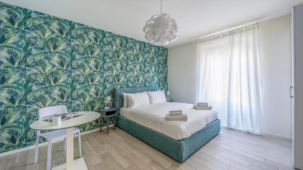 um quarto com uma cama e uma parede arborizada verde em Italianway - The B Village New em Milão